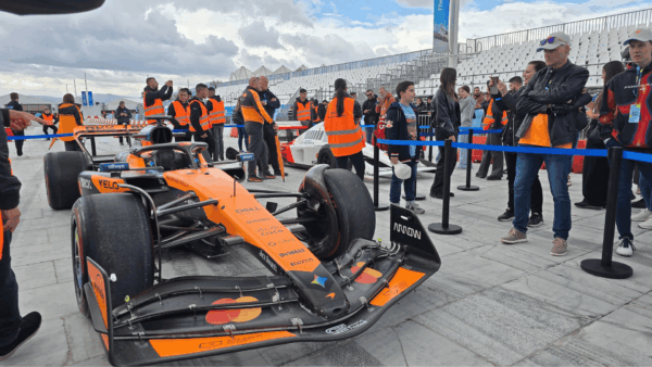 Η McLaren MCL60 σε πρώτο πλάνο και η ιστορική MP4/6 στο βάθος, με επισκέπτες γύρω από τα δύο μονοθέσια στο ΟΑΚΑ.